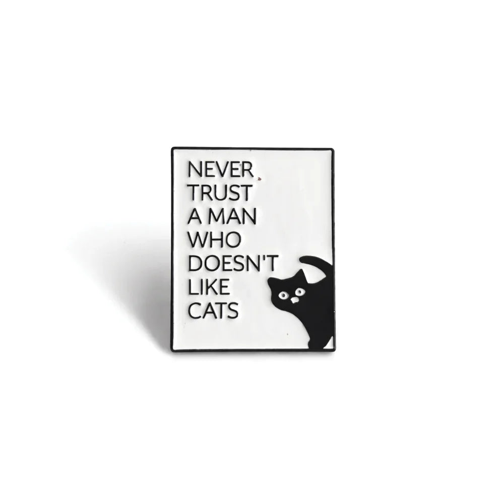Soulpurrpose enamel pin with 'Never trust a man who doesn’t like cats' text and black cat illustration.