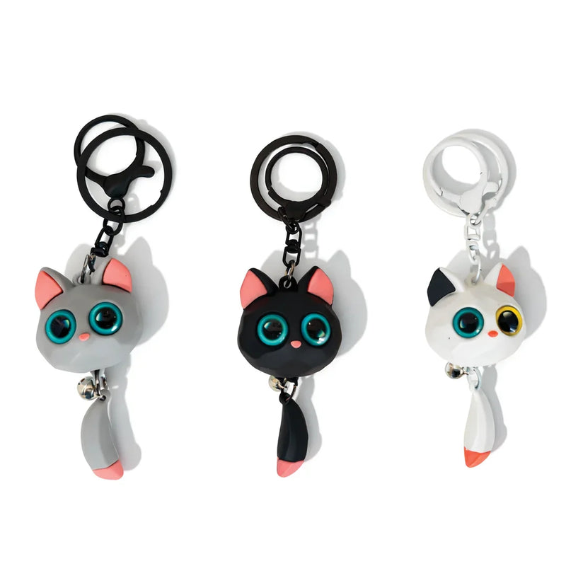Three cute cat keychains with big turquoise eyes, inspired by Soulpurrpose, on white background