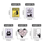 Set of five cat-themed enamel pins with playful slogans, black cat designs, and size details