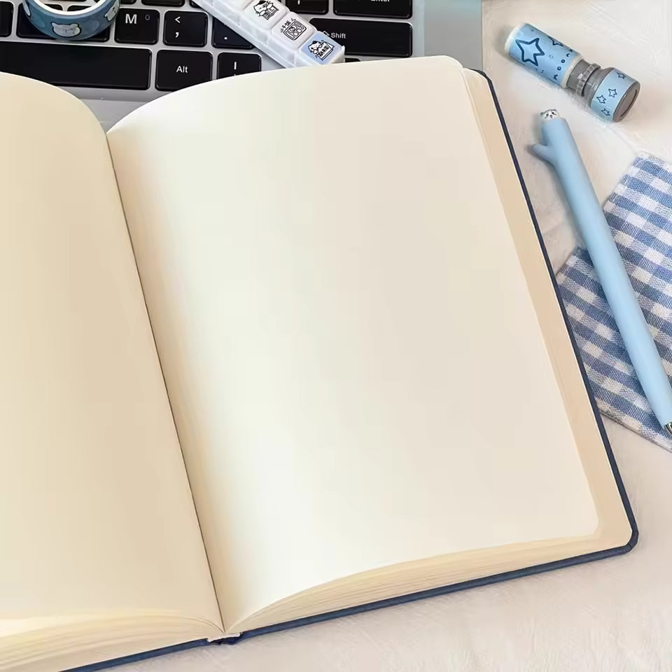 Open blank notebook on laptop with blue pen and cute animal-themed stationery, Soulpurrpose